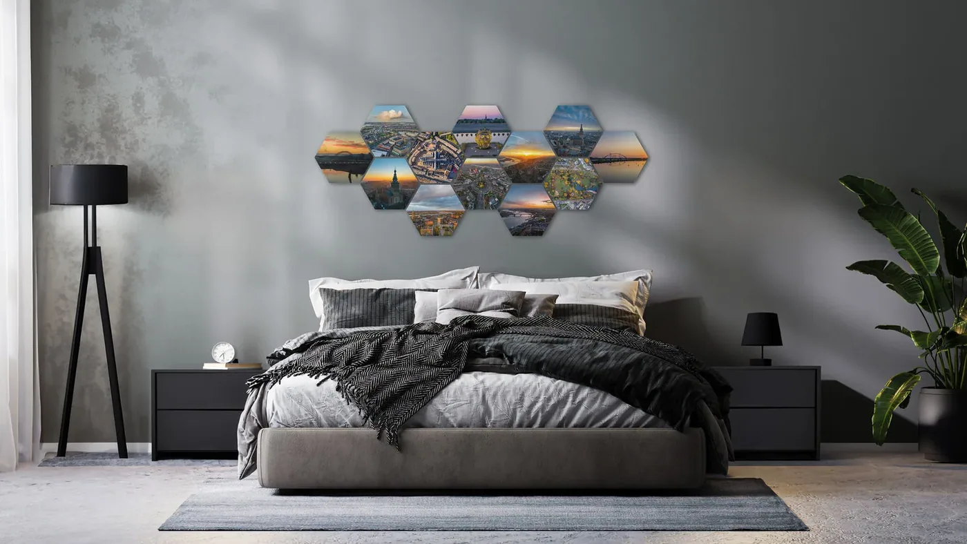 Grote hexagon fotowand van luchtfoto's boven het bed in een grijze slaapkamer