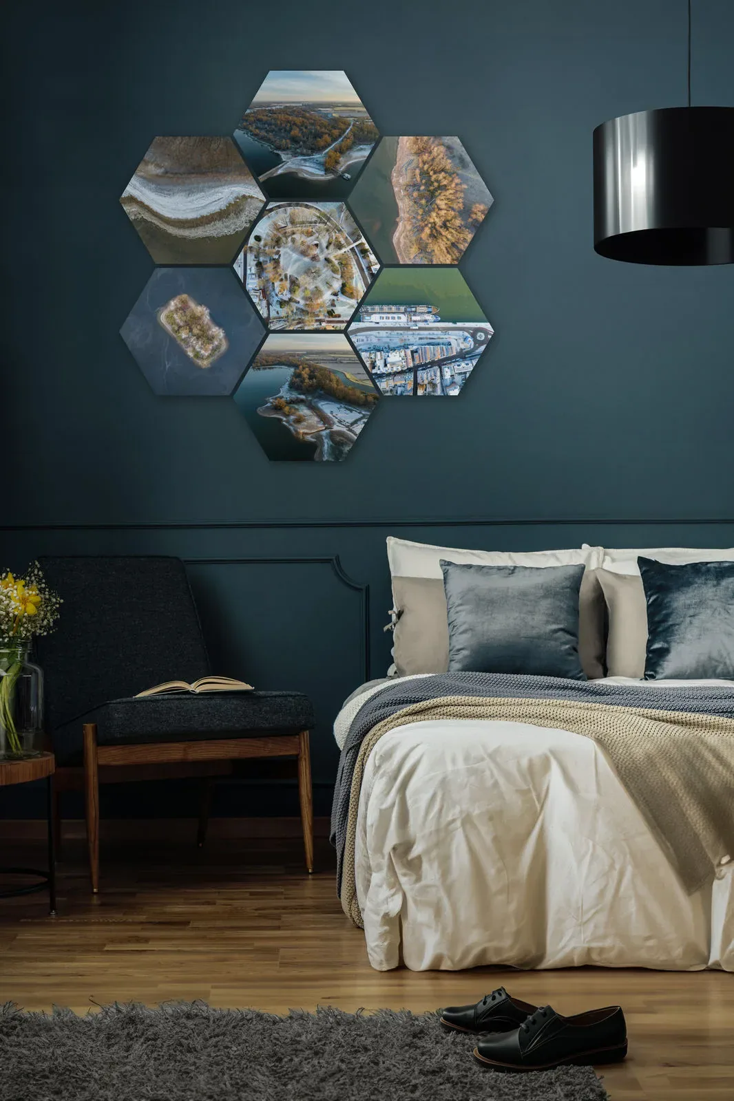 Zes hexagons met luchtfoto's als fotowand boven het bed, op een donkerblauwe muur