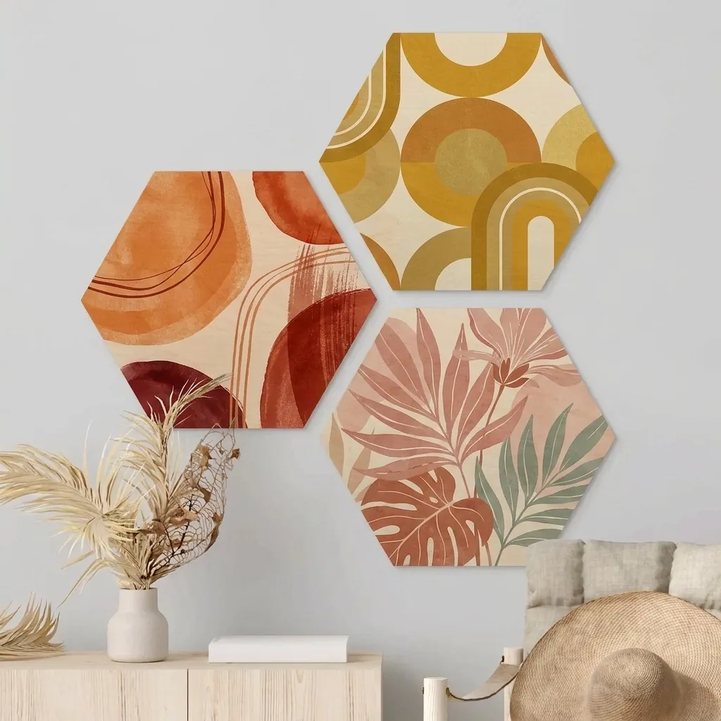 Drie hexagons op hout met abstracte kunstprints in terracotta, oker en roze boven een dressoir