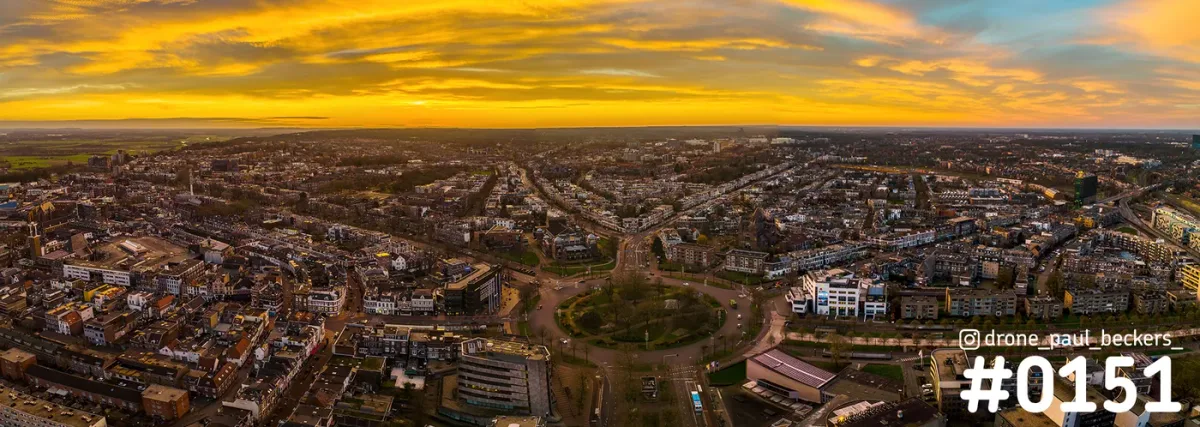 Luchtpanorama van Keizer Karel Plein in Nijmegen onder een oranje gekleurde lucht, met de rotonde en de stad eromheen