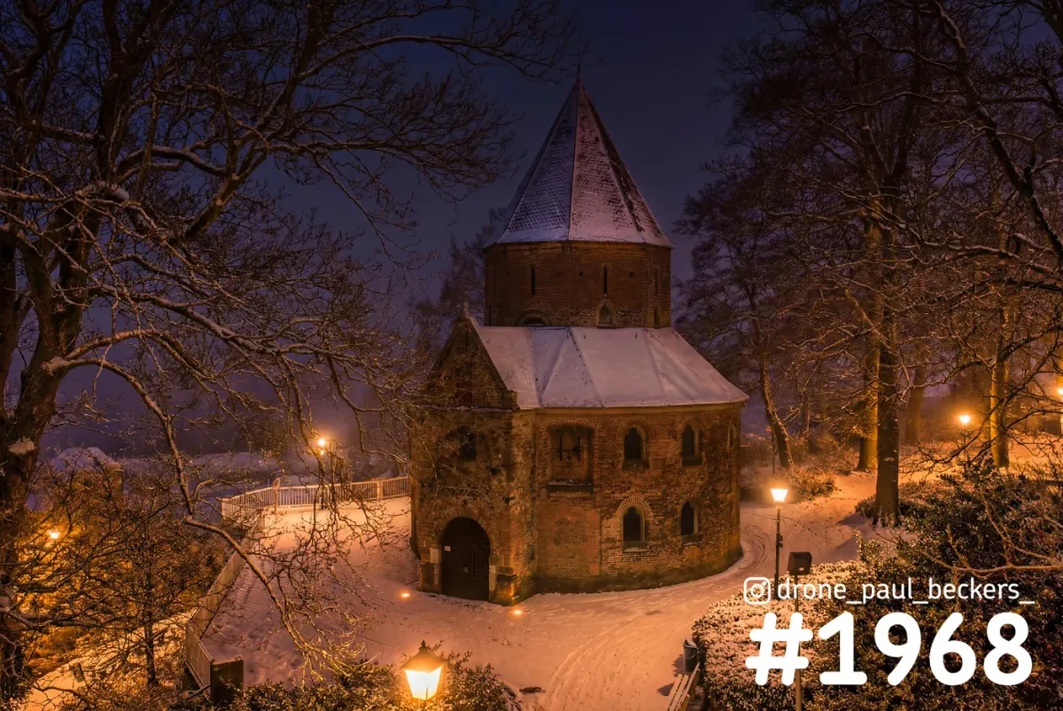 Luchtfoto van de Sint-Nicolaaskapel in het Kronenburgerpark in Nijmegen, 's avonds in de sneeuw bij lantaarnlicht