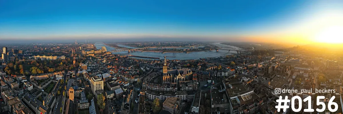 Luchtpanorama van Nijmegen met de Stevenskerk, de Waal en de bruggen in warm zonlicht bij zonsopkomst of zonsondergang