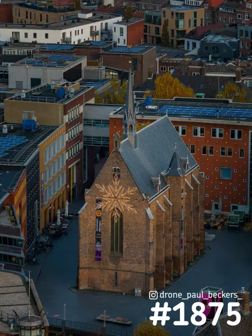 Luchtfoto van de Marienburg kapel in het centrum van Nijmegen met verlichte sneeuwvlok op de gevel in het avondlicht