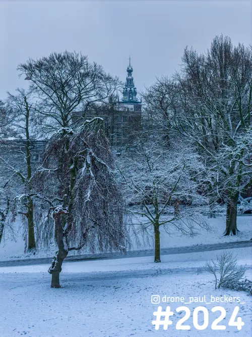 Toren van de Stevenskerk boven besneeuwde bomen in het Kronenburgerpark in Nijmegen, met sneeuw op alle takken