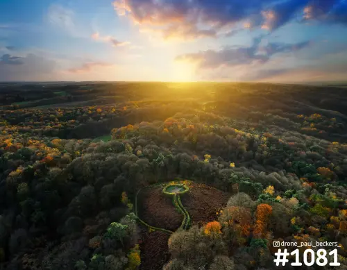 Luchtfoto van herfstbos op de Duivelsberg bij Nijmegen met laagstaande zon en een kleine vijver in een open plek