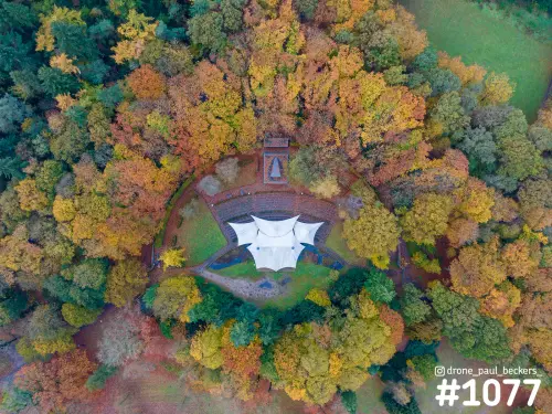 Luchtfoto van een openluchttheater met wit dak in herfstbos bij de Goffert in Nijmegen, recht van boven gezien