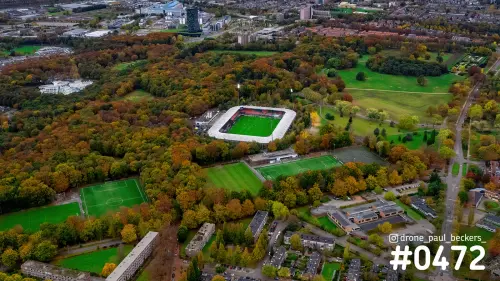 Luchtfoto van het stadion in de Goffert in Nijmegen met herfstkleurige bomen en meerdere voetbalvelden eromheen