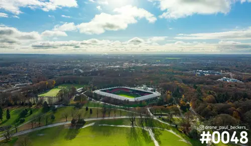 Luchtfoto van het stadion bij de Goffert in Nijmegen in de herfst, omringd door bomen met oranje bladeren en grasvelden