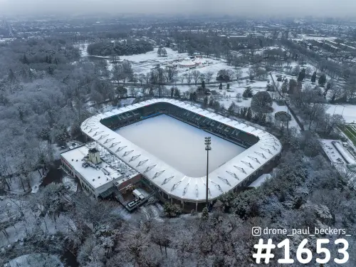 Luchtfoto van het Goffertstadion in Nijmegen onder een laag sneeuw, met besneeuwd veld en bomen in het park eromheen