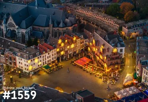 Luchtfoto van de Grote Markt in Nijmegen in de avondschemering, met gouden sterren aan de gevels naast de Stevenskerk