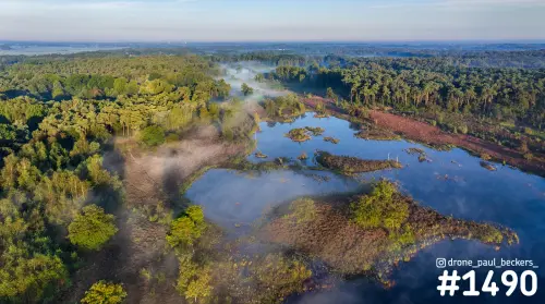 Luchtfoto van de Hatertse Vennen bij Nijmegen met laaghangende mist boven vennen, heide en bos in warm ochtendlicht