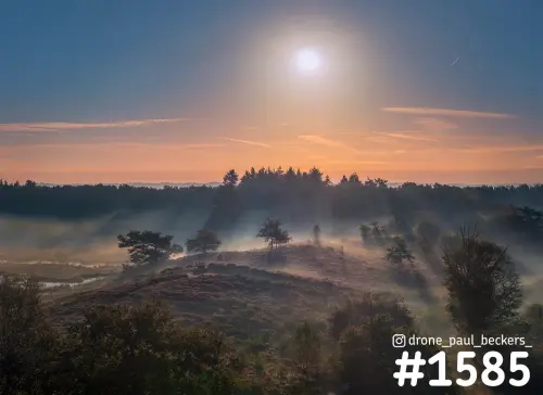 Luchtfoto van de Hatertse Vennen bij Nijmegen met lage zon, mist tussen de heuvels en bomen op de heide