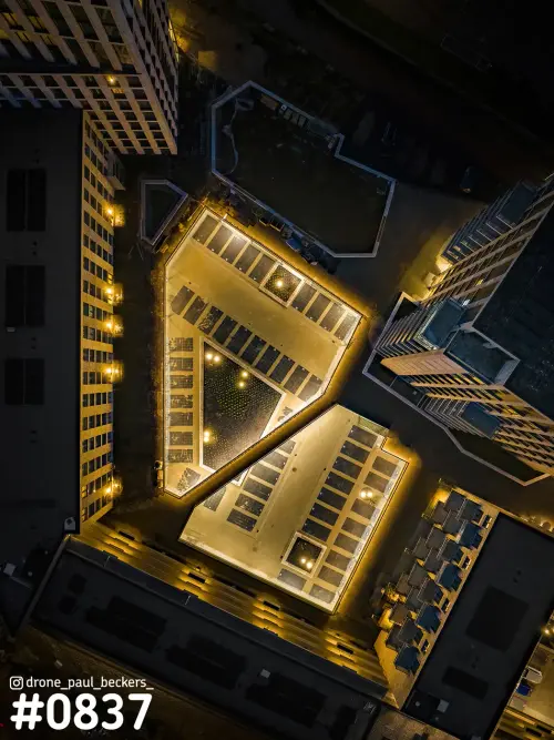 Luchtfoto recht van boven op daken en binnenplaatsen in het Havenkwartier in Nijmegen, 's avonds in gouden licht