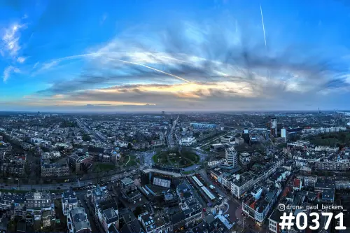Luchtfoto van Keizer Karel Plein in Nijmegen in de schemering, met condensstrepen in een blauwe lucht boven de stad