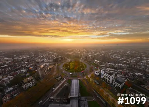 Luchtfoto van het Keizer Karel Plein in Nijmegen in herfstkleuren, met oranje zonsopkomst en mist boven de stad