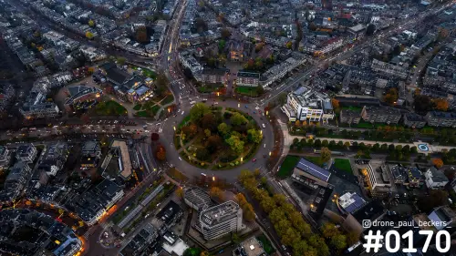 Luchtfoto van het Keizer Karel Plein in Nijmegen in de schemering, met verlichte rotonde en herfstkleurige bomen