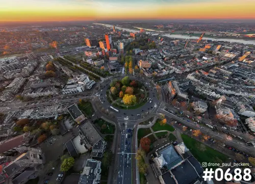 Luchtfoto van Keizer Karel Plein in Nijmegen met herfstbomen in de rotonde, Kronenburgerpark en oranje horizon