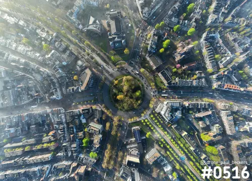 Luchtfoto recht van boven op het Keizer Karel Plein in Nijmegen: rotonde met bomen in het midden en lanen in lentelicht