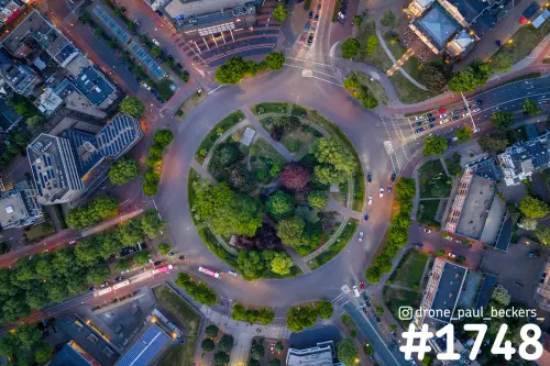 Luchtfoto recht van boven op de rotonde Keizer Karel Plein in Nijmegen in het schemerlicht, met groen middeneiland en verkeer