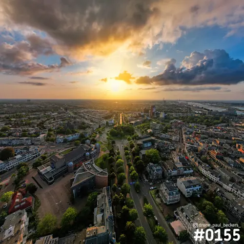 Luchtfoto van Keizer Karel Plein in Nijmegen bij zonsondergang, met donkere wolken en de Waal aan de horizon