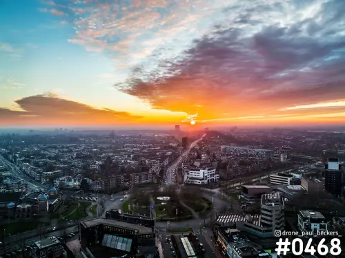 Luchtfoto van het Keizer Karel Plein in Nijmegen bij zonsopkomst, met oranje wolken boven de stad en een lange straat naar de horizon