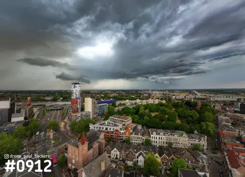 Luchtfoto van Nijmegen met donkere wolken boven het Kronenburgerpark, het stationsgebied en De Oversteek