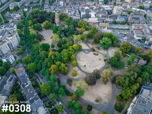 Luchtfoto van Kronenburgerpark in Nijmegen met droge grasvelden, een rond wandelpad en een ronde bakstenen toren