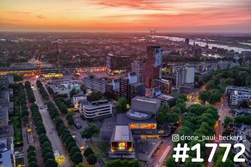 Luchtfoto van de Stadsschouwburg en het Kronenburgerpark in Nijmegen bij schemering, met de Waal aan de horizon