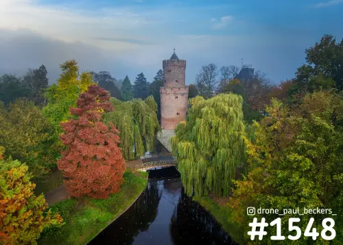 Luchtfoto van de bakstenen toren in Kronenburgerpark Nijmegen, met rode herfstboom en treurwilg langs het water