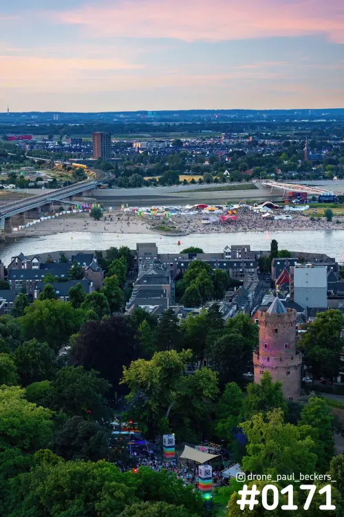 Luchtfoto van het Kronenburgerpark in Nijmegen met ronde stenen toren, de Waal en festivalterrein bij zonsondergang