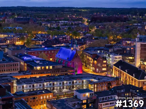 Luchtfoto van de Marienburg kapel in het centrum van Nijmegen in de avondschemering, met paars en roze verlicht dak