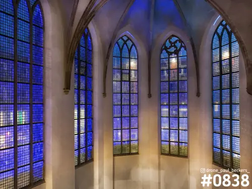 Spitsboogvensters in de Marienburg kapel in Nijmegen 's avonds, met blauw licht door de ruitjes en ribgewelf erboven