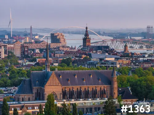 Luchtfoto van de Marienburg kapel in Nijmegen met de Stevenskerk, de Waal en brug De Oversteek in warm zonlicht