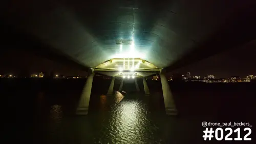 Luchtfoto onder een betonnen brug over de nevengeul van de Waal in Nijmegen, 's nachts met lichtreflecties in het water