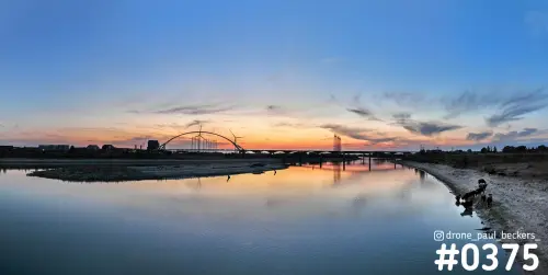 Panorama van de Nevengeul bij Nijmegen na zonsondergang, met De Oversteek als silhouet en dieren aan de oever