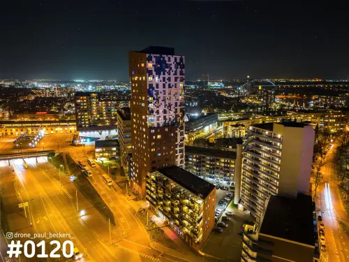 Luchtfoto van de Nimbus-toren in het Stationsgebied van Nijmegen bij nacht, met verlichte wegen en sterren boven de stad