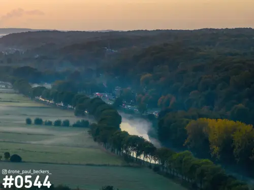 Luchtfoto van de Ooijpolder bij Nijmegen met ochtendmist boven een waterbocht en herfstkleurige bossen