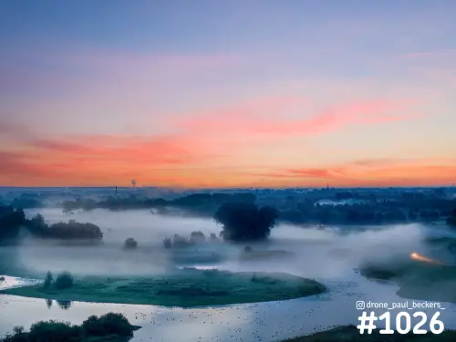 Luchtfoto van de Ooijpolder bij Nijmegen in de vroege ochtend, met mist boven het water en een roze en oranje lucht