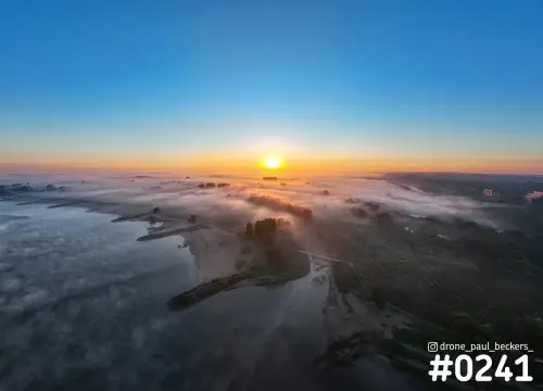 Luchtfoto van de Waal bij de Ooijpolder in Nijmegen met laaghangende mist en de zon die opkomt achter de uiterwaarden