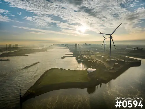 Luchtfoto van De Oversteek over de Waal in Nijmegen met havenpunt, windturbines en laagstaande zon door de mist