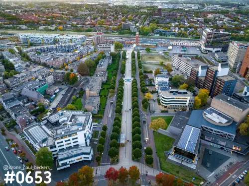 Luchtfoto van het stationsgebied in Nijmegen in de herfst, met een laan tussen bomenrijen en de Stadsschouwburg rechts