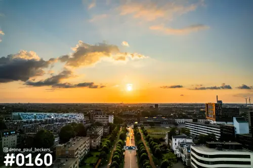 Luchtfoto van het Stationsgebied in Nijmegen bij laagstaande zon, met een laan met bomen richting de horizon