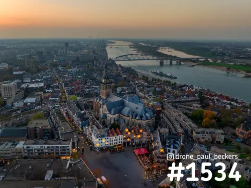 Luchtfoto van de Stevenskerk aan de Grote Markt in Nijmegen in schemering, met verlichte sterren op de gevels