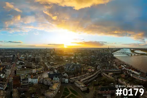Luchtfoto van het centrum van Nijmegen met de Stevenskerk en de Waal bij laagstaande zon en een wolkenlucht
