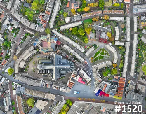 Luchtfoto recht van boven op de Stevenskerk en de Grote Markt in Nijmegen, met herfstkleuren in de bomen en gebogen woonblokken