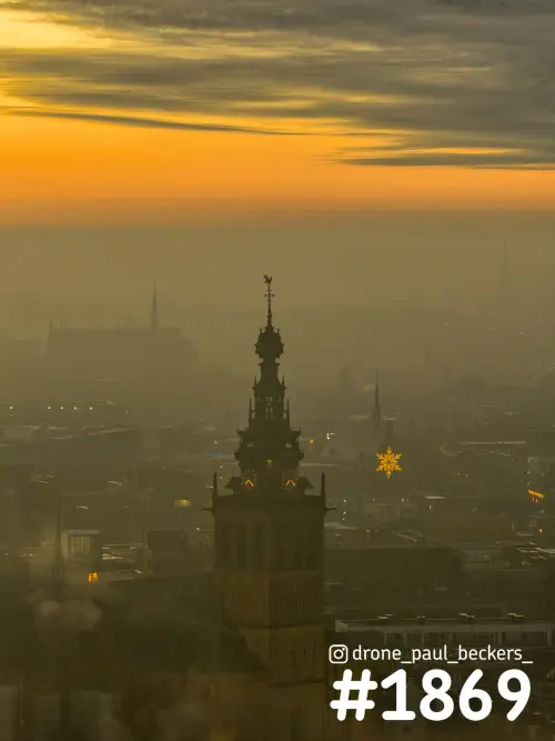 Luchtfoto van de Stevenskerk in Nijmegen in oranje licht, met mist over het centrum en een lichtgevende ster