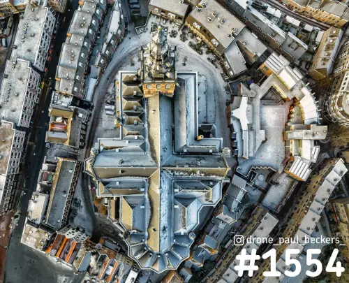 Luchtfoto recht van boven op de Stevenskerk in Nijmegen, met een dun laagje sneeuw op de daken rond het kruisvormige kerkdak