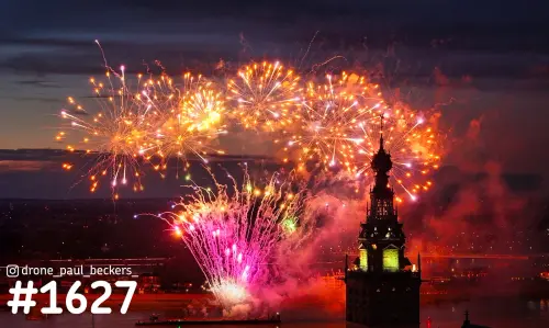 Luchtfoto van vuurwerk boven de Stevenskerk in Nijmegen tijdens de Vierdaagse, met roze en oranje rookwolken