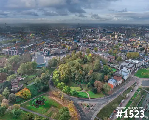 Luchtfoto van het Valkhof gebied in Nijmegen in de herfst, met kleurende bomen en het centrum onder een grijze lucht