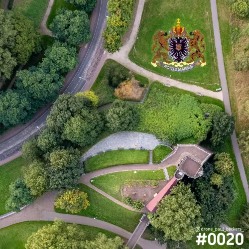 Luchtfoto van het Valkhof in Nijmegen met een bloemenwapen met adelaar en twee leeuwen naast kronkelende paden